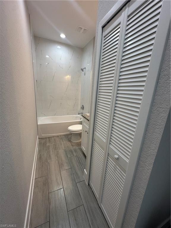 Full bathroom with vanity, toilet, and tiled shower / bath