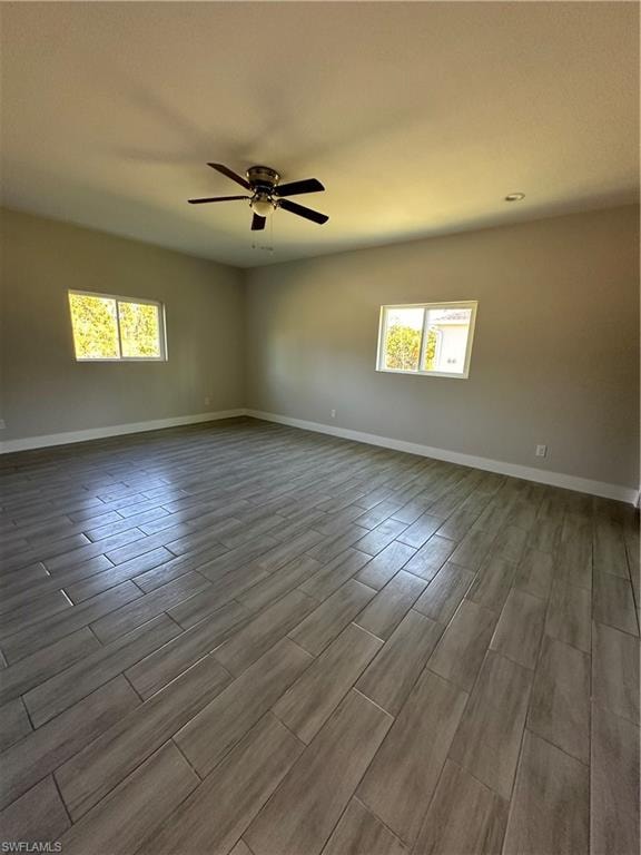 Unfurnished room with wood-type flooring, ceiling fan, and a healthy amount of sunlight