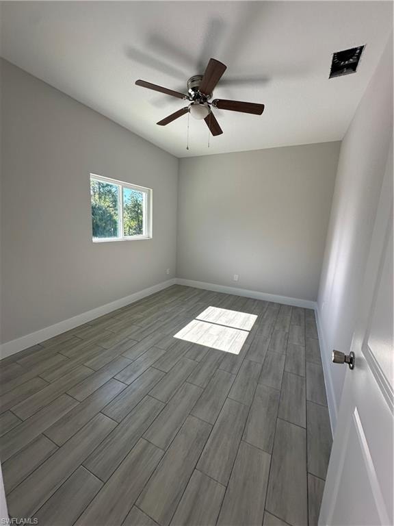 Empty room with ceiling fan and wood-type flooring