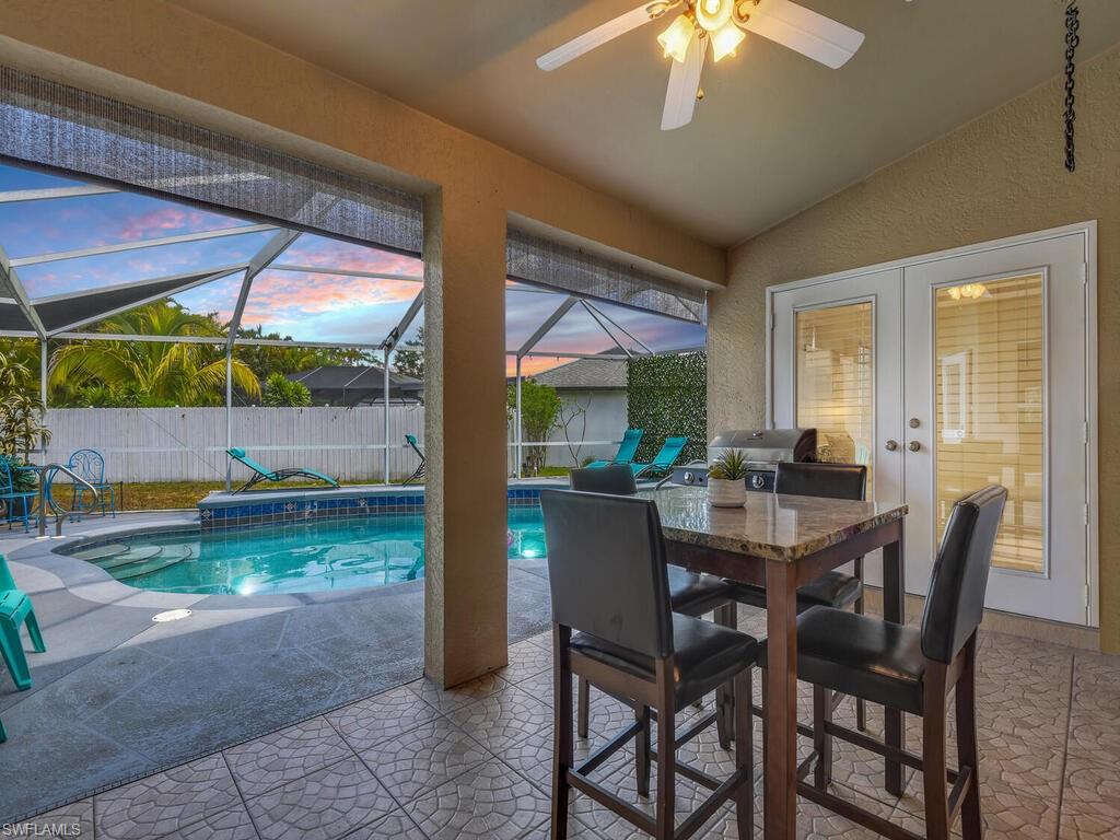 Pool at dusk with a patio and glass enclosure