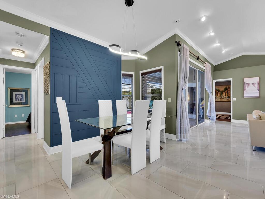 Dining room featuring lofted ceiling and ornamental molding