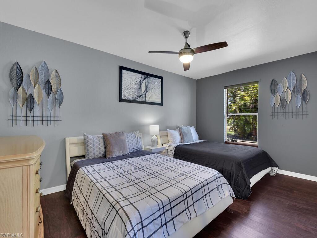 Bedroom with ceiling fan and dark hardwood / wood-style flooring