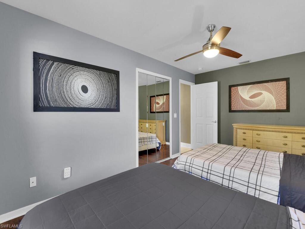 Unfurnished bedroom with connected bathroom, ceiling fan, and dark wood-type flooring
