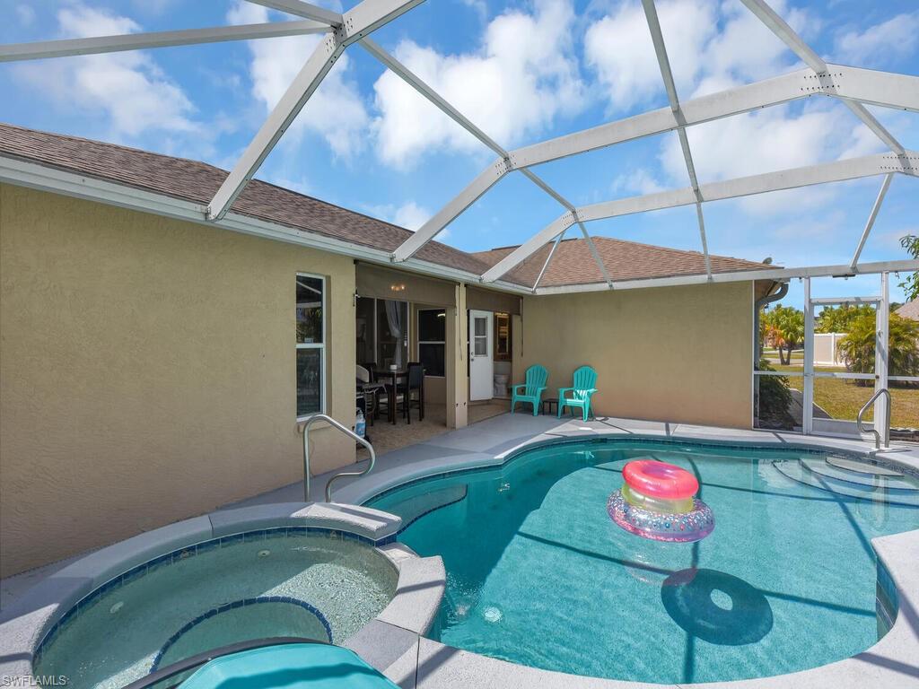 View of swimming pool with an in ground hot tub, a patio area, and a lanai