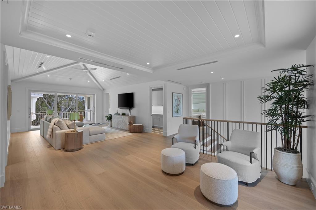 Living room with lofted ceiling with beams, wood ceiling, and light hardwood / wood-style floors