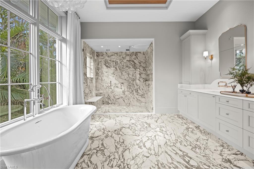 Bathroom featuring separate shower and tub and vanity
