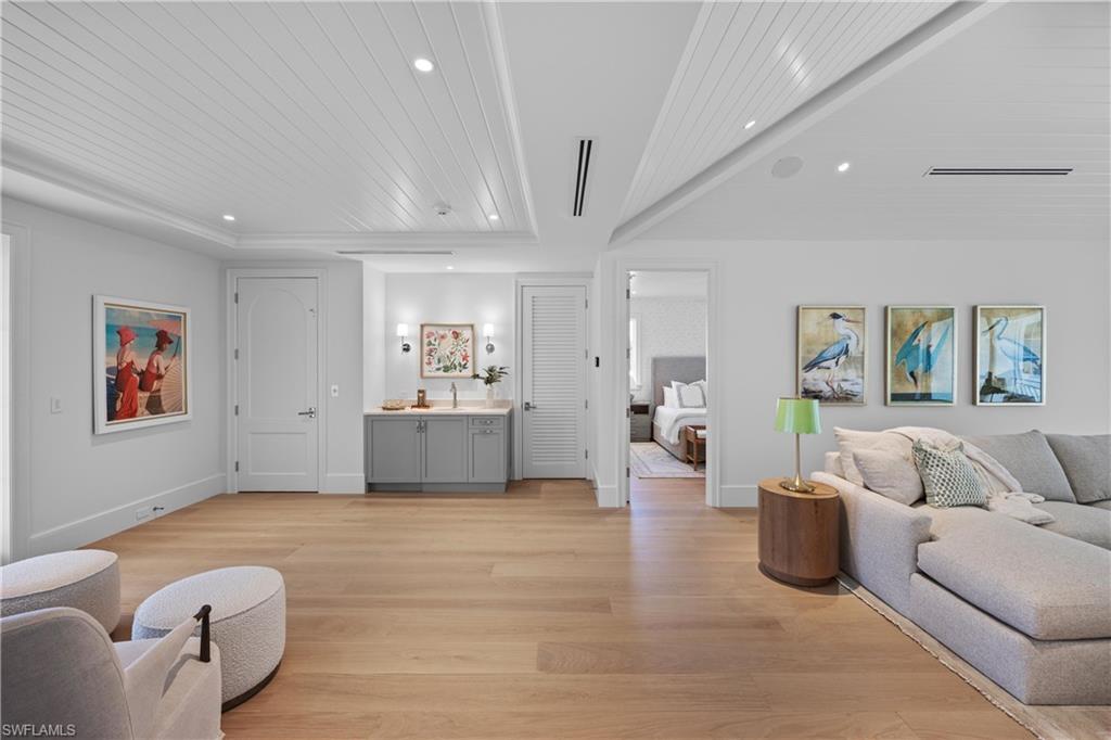 Living room featuring light wood-type flooring, sink, and wooden ceiling