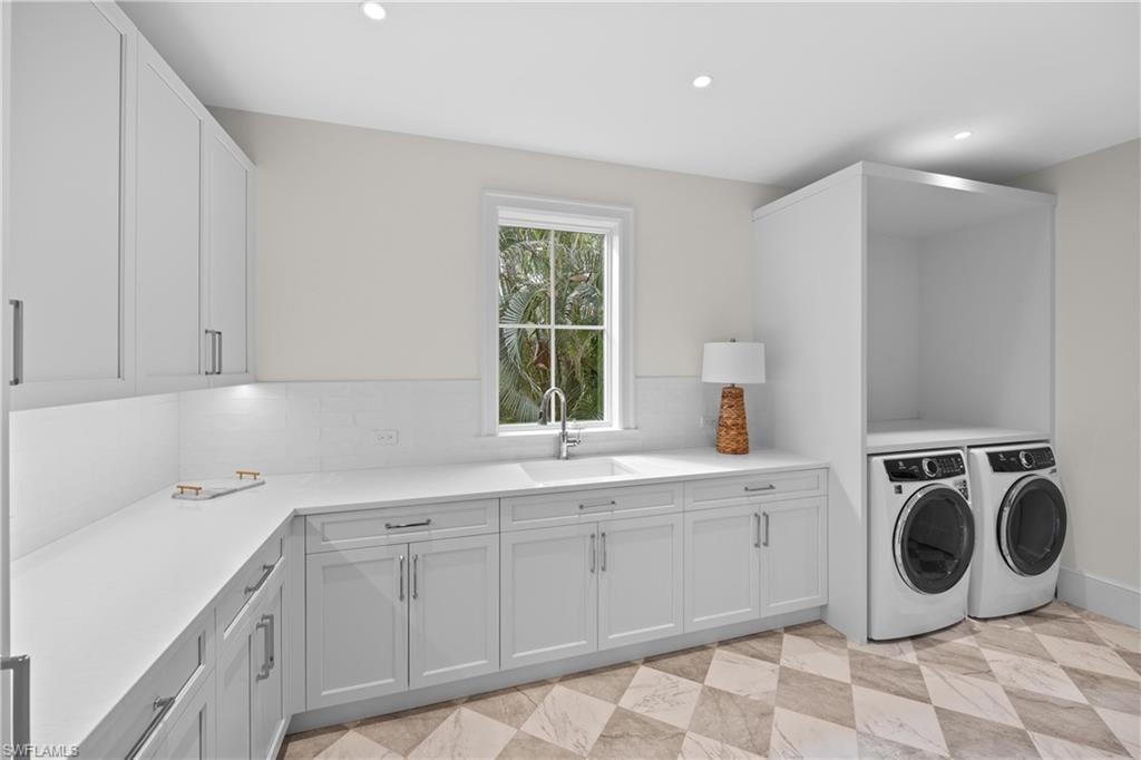 Laundry room featuring cabinets, washer and dryer, and sink