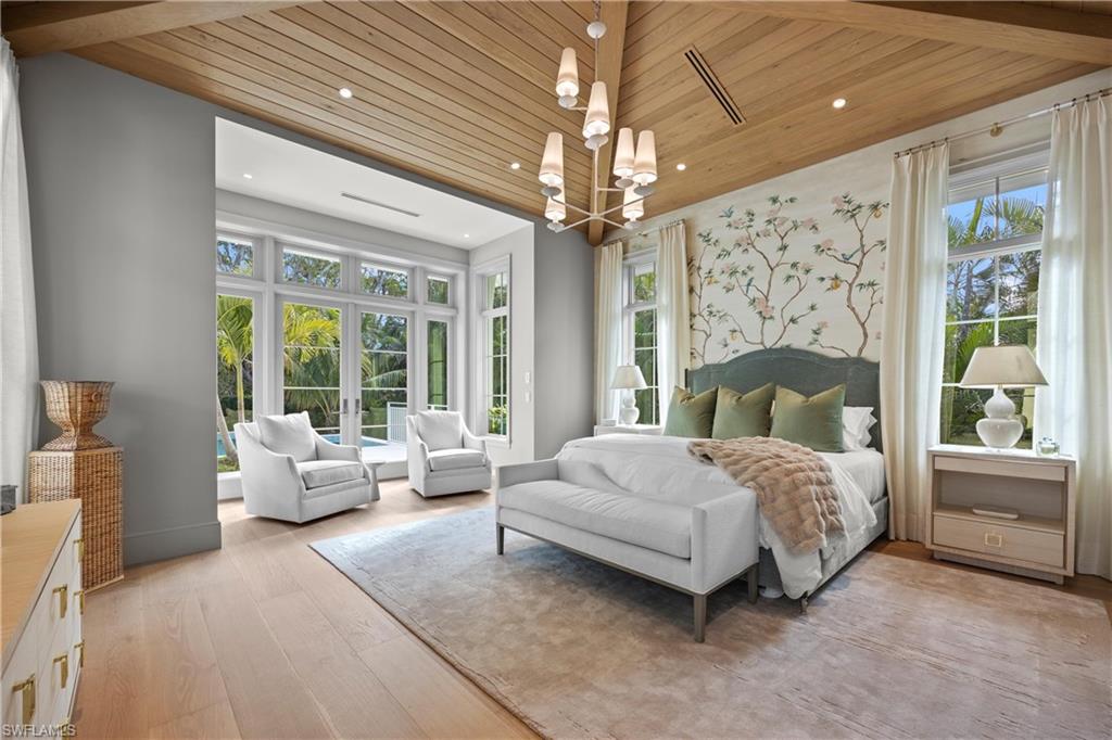 Bedroom featuring wood ceiling, multiple windows, french doors, an inviting chandelier, and light hardwood / wood-style floors