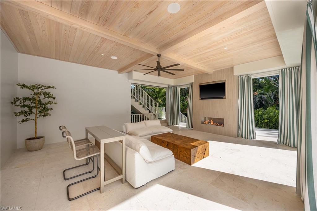 Living room with ceiling fan, wood ceiling, a healthy amount of sunlight, and beam ceiling