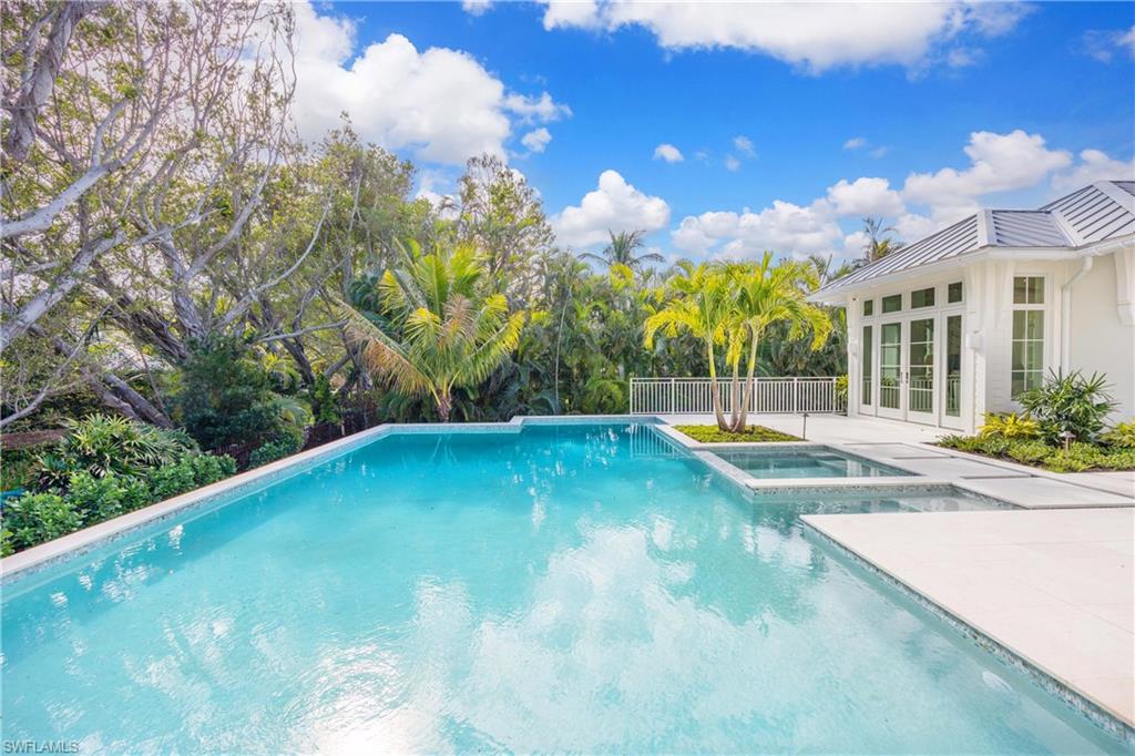 View of pool featuring french doors, a patio area, and an in ground hot tub