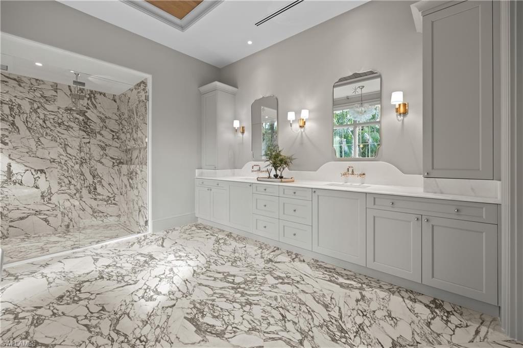 Bathroom featuring a tile shower and vanity