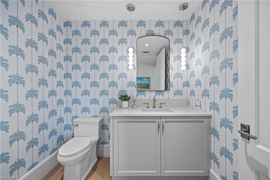 Bathroom with toilet, hardwood / wood-style flooring, and vanity