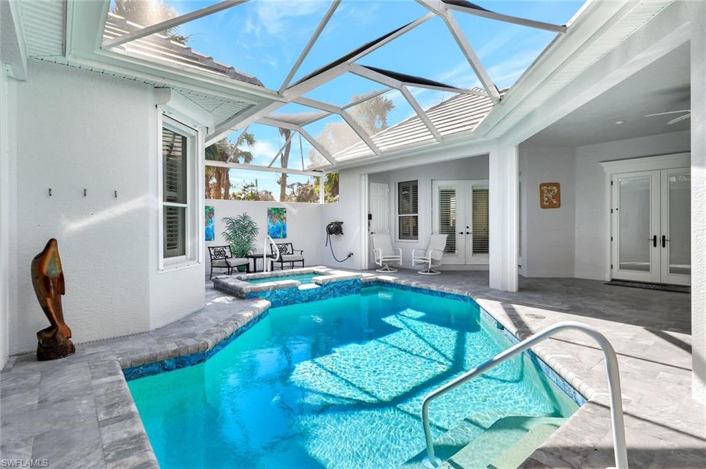 View of pool featuring a lanai, an in ground hot tub, french doors, and a patio