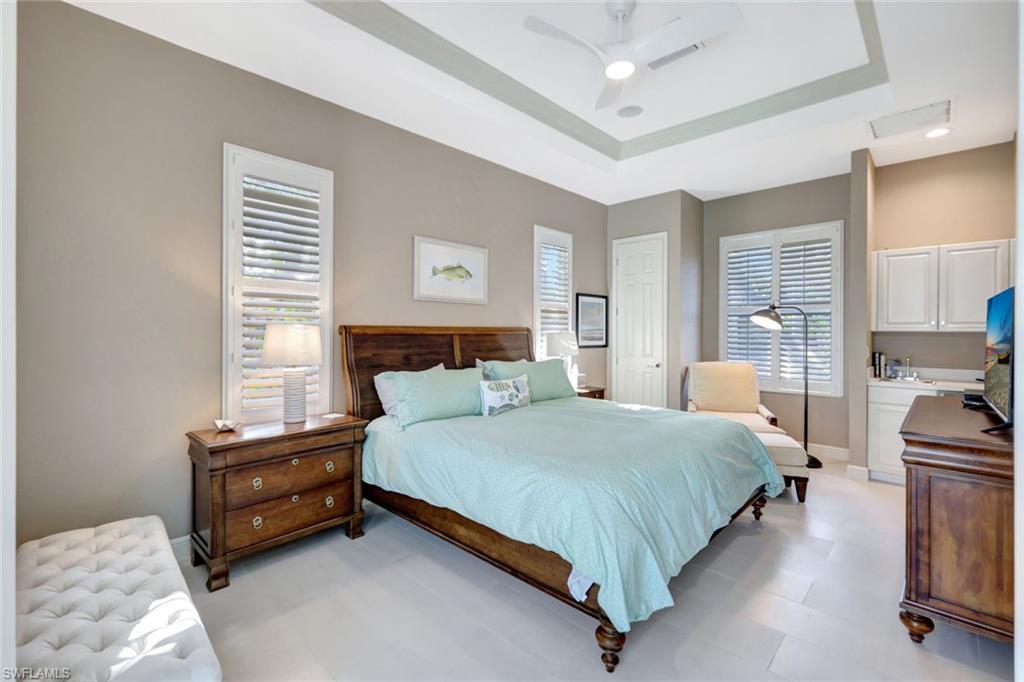 Casita guest bedroom featuring ceiling fan and a tray ceiling; attached bath & breakfast bar area