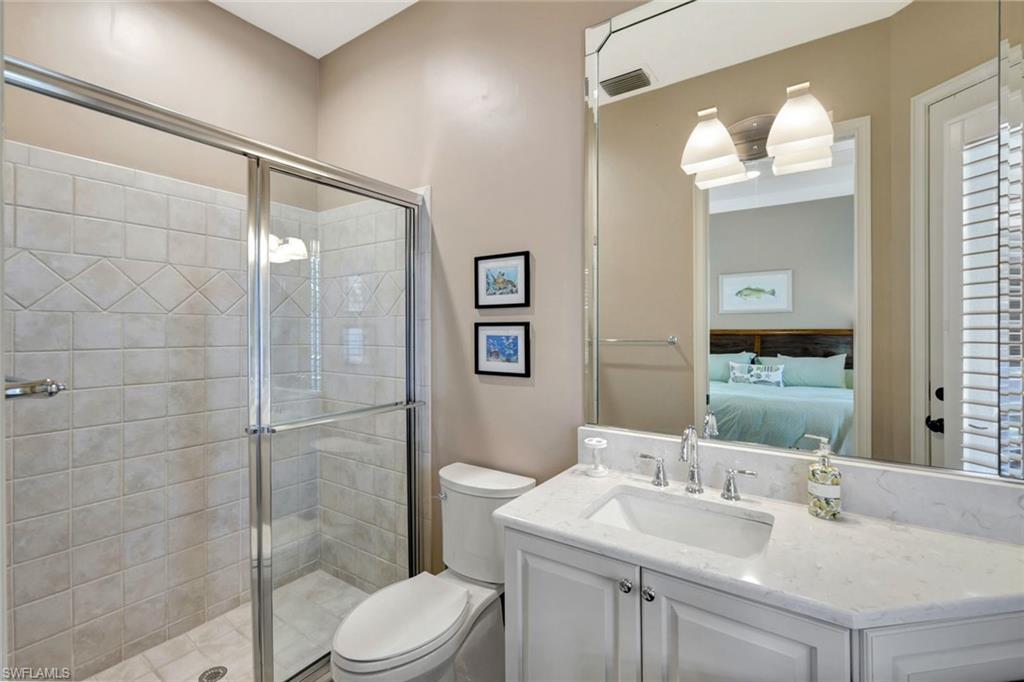 Bathroom featuring vanity, toilet, and a shower with shower door
