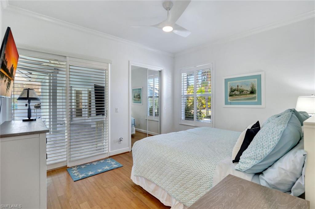 Bedroom featuring ceiling fan, light wood-type flooring, and crown molding right off of pool