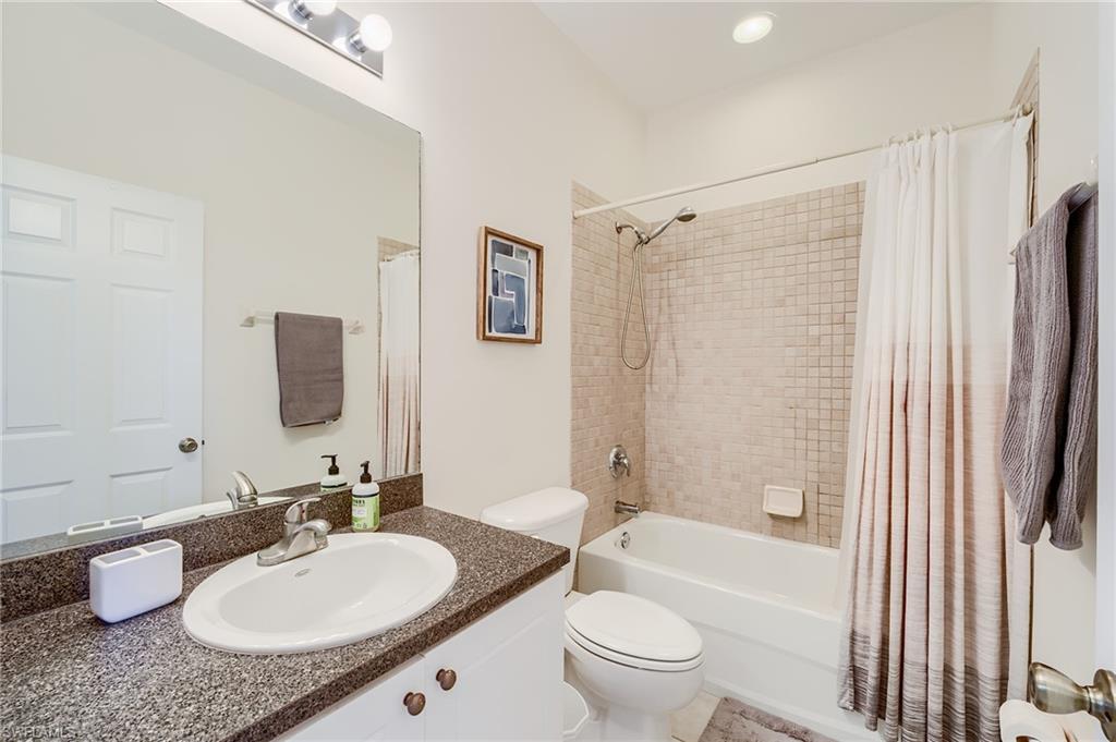 Full bathroom featuring vanity, shower / bath combo, and toilet