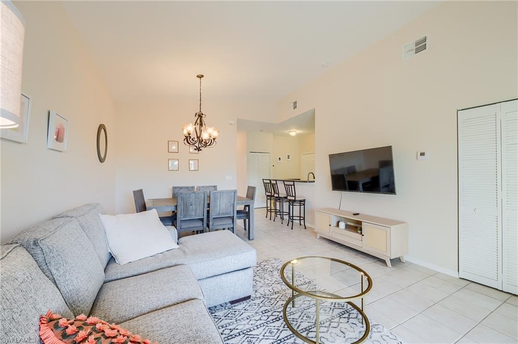 Tiled living room featuring a notable chandelier