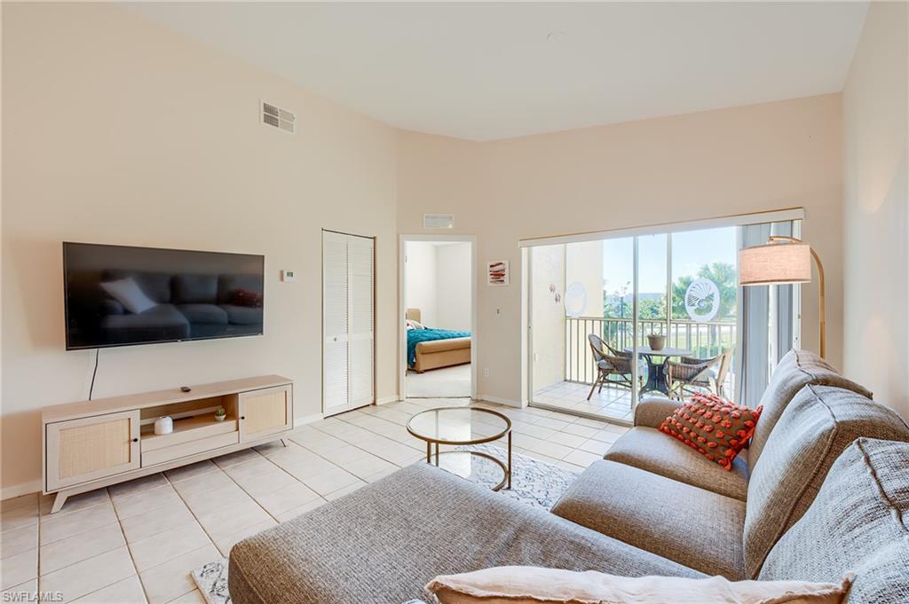 Living room with a high ceiling and light tile patterned flooring