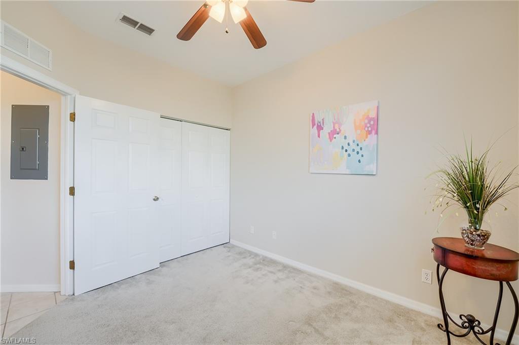 Unfurnished bedroom featuring electric panel, light carpet, a closet, and ceiling fan