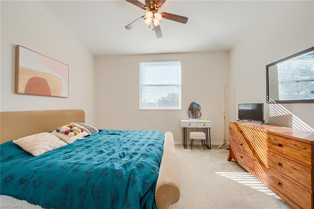 Carpeted bedroom featuring ceiling fan