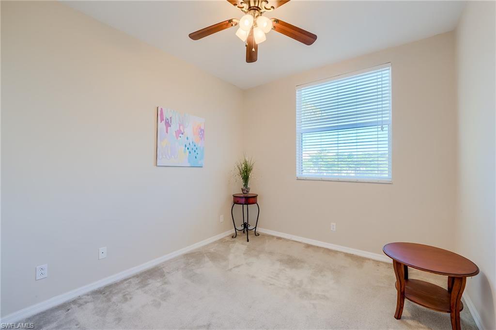 Carpeted spare room featuring ceiling fan