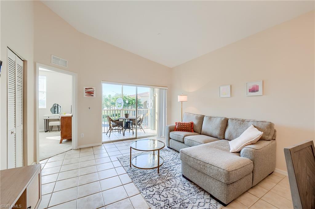 Tiled living room featuring high vaulted ceiling