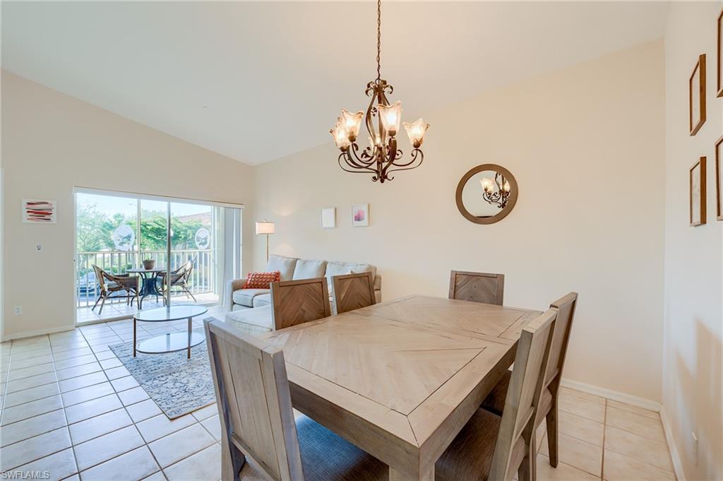 Tiled dining room featuring an inviting chandelier and vaulted ceiling