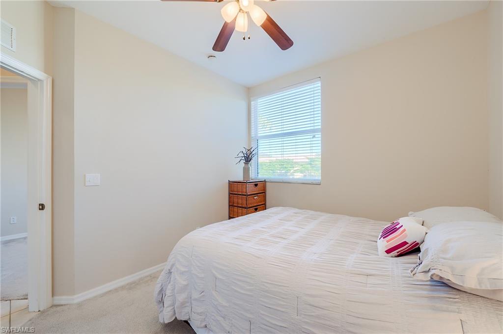 Bedroom with ceiling fan and light colored carpet