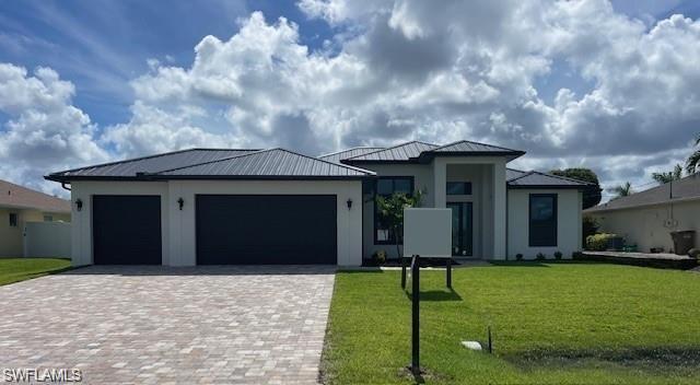 View of front facade featuring a garage and a front lawn