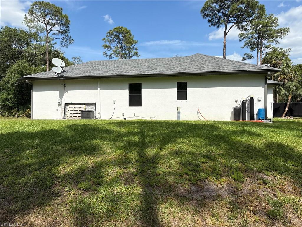View of side of home featuring a yard and stucco siding