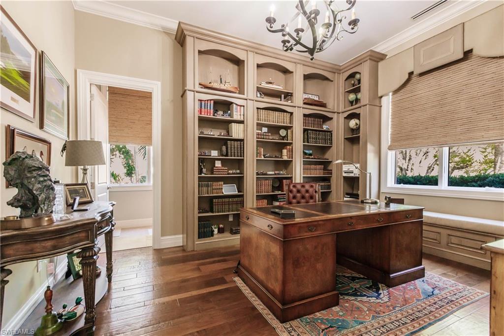 Office space with ornamental molding, dark hardwood / wood-style flooring, and a chandelier