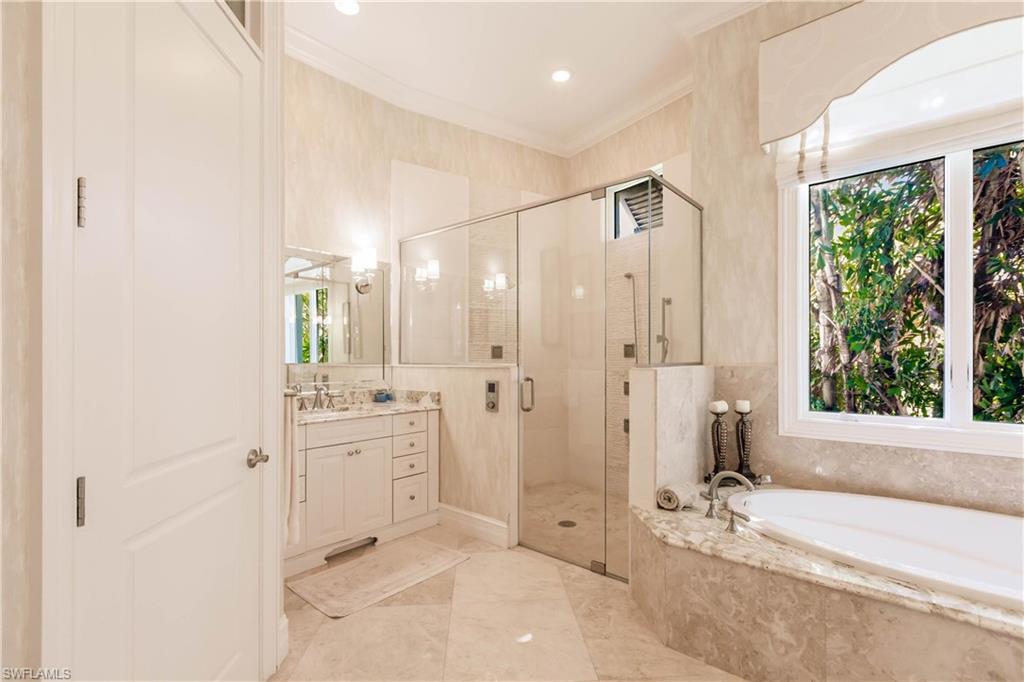 Bathroom with crown molding, separate shower and tub, and vanity