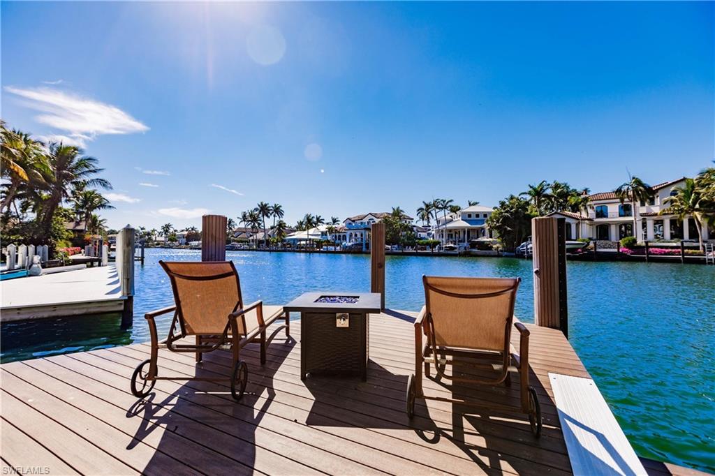 View of dock featuring a fire pit and a water view