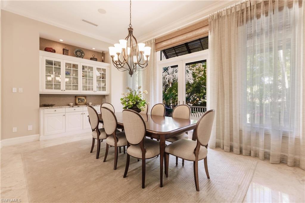 Dining room featuring ornamental molding and a notable chandelier