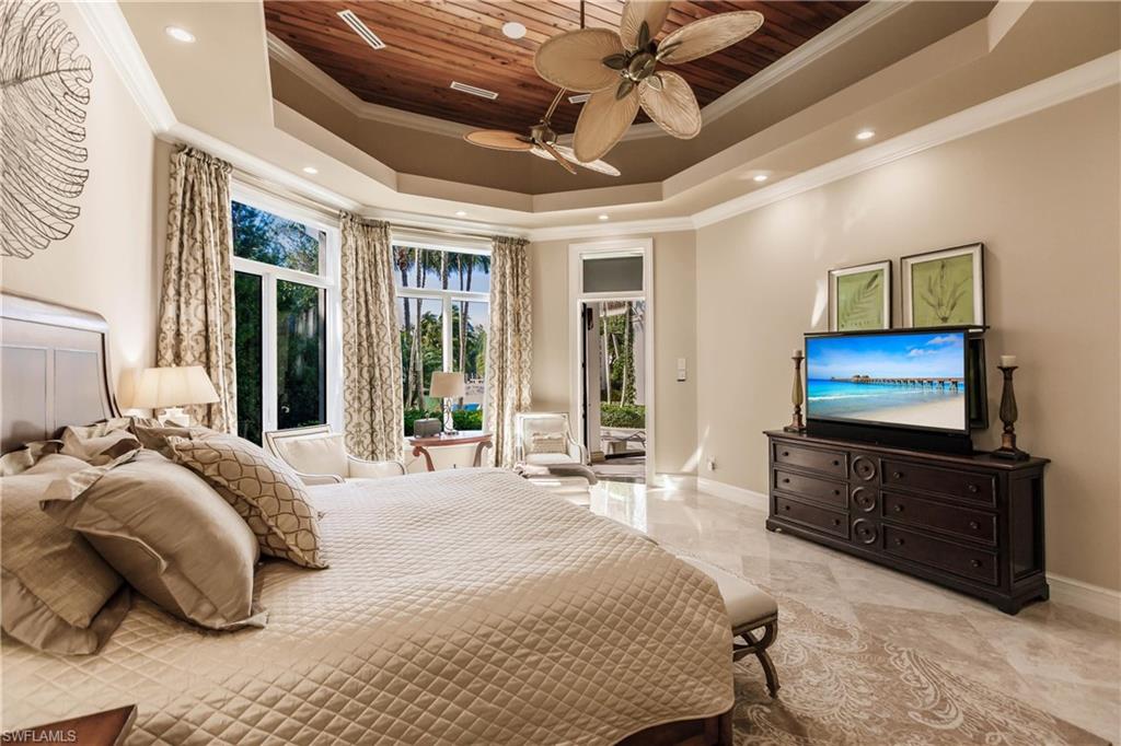 Bedroom featuring wood ceiling, ceiling fan, a tray ceiling, ornamental molding, and access to outside