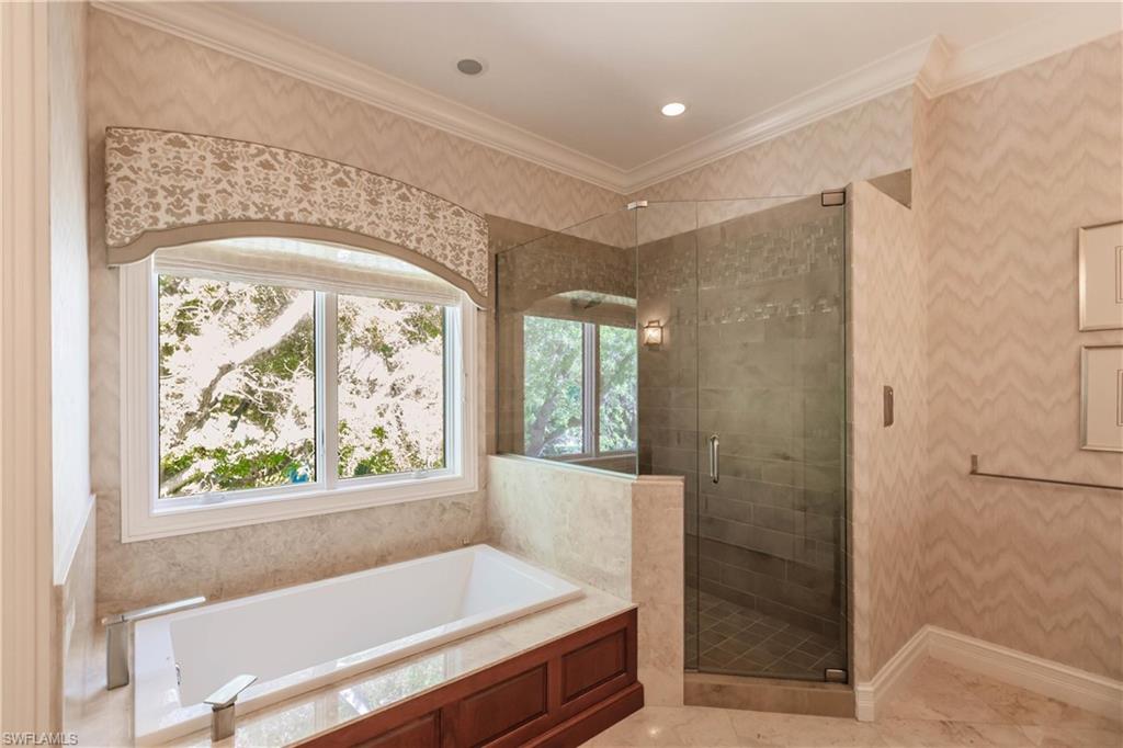 Bathroom featuring independent shower and bath and ornamental molding