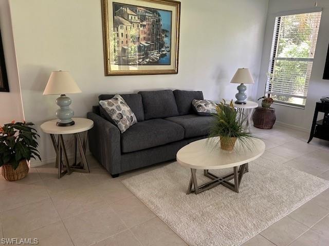Living area featuring light tile patterned floors and baseboards