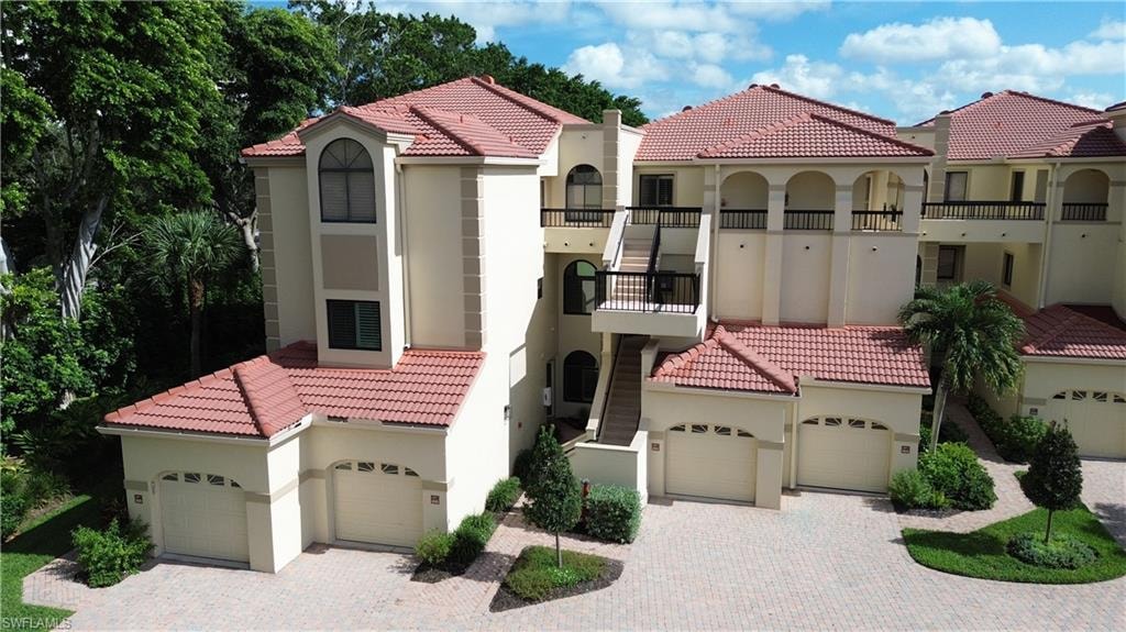 Mediterranean / spanish-style home with stucco siding, a tile roof, a balcony, and a garage