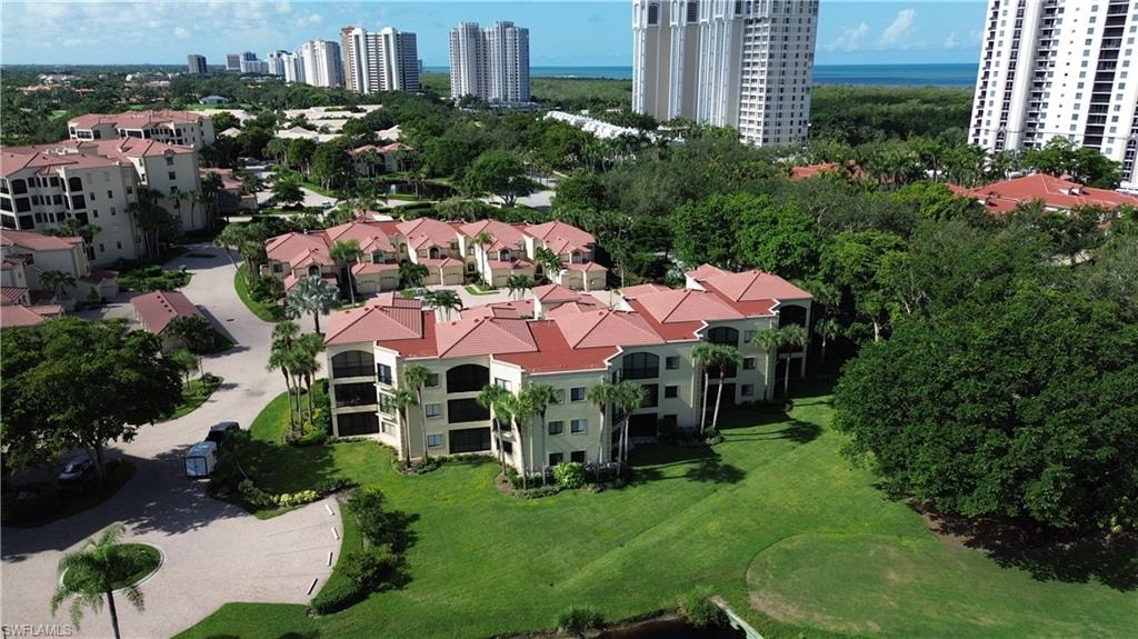 Drone / aerial view of a nearby body of water and apartment complex / building