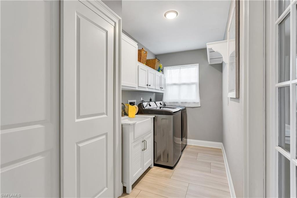 Laundry area featuring washing machine and clothes dryer and cabinets