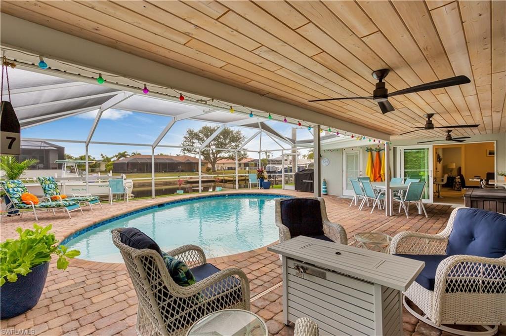 View of pool with screened  enclosure and a patio