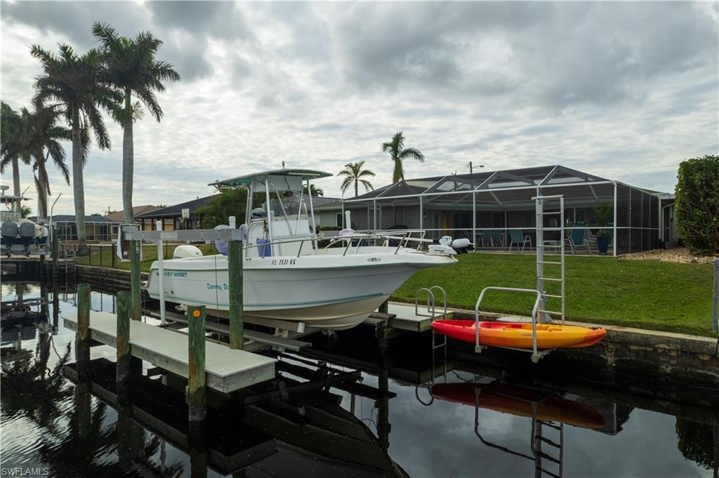 View of dock featuring a water view and a lawn