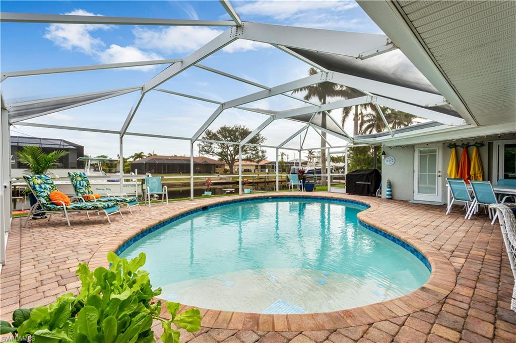 View of pool with a grill, a patio area, and a lanai