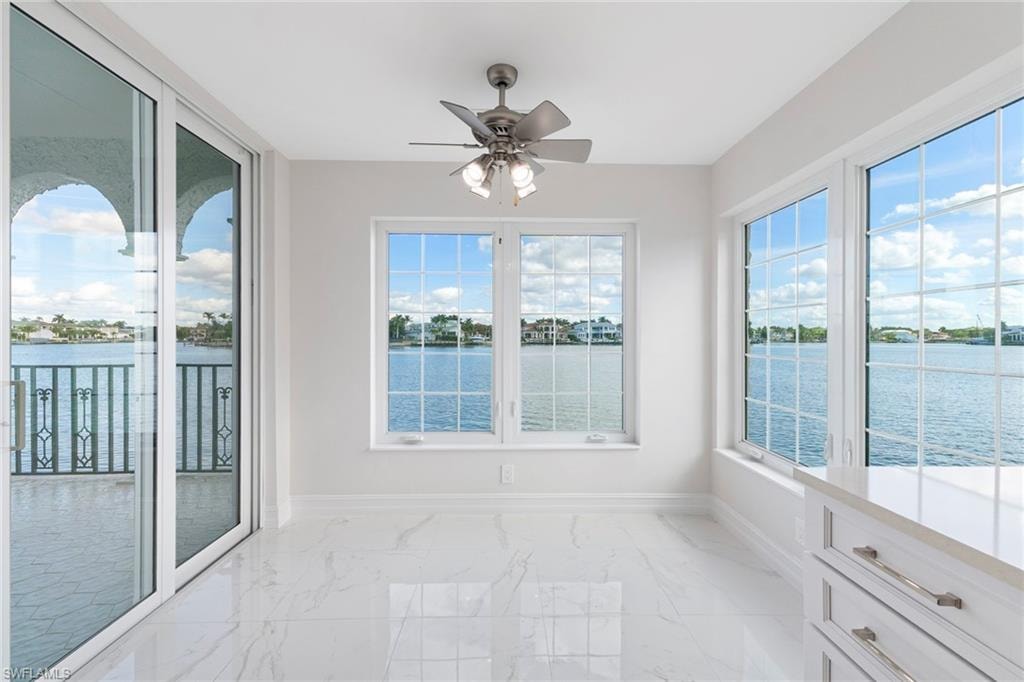Unfurnished sunroom featuring a water view and plenty of natural light