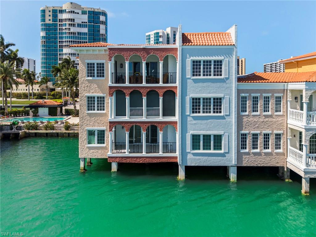 Back of property with stucco siding, a water view, and a tiled roof