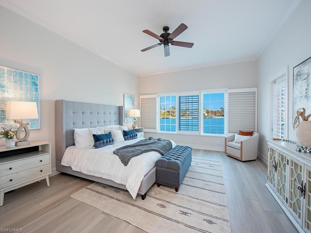 Bedroom featuring ceiling fan, light hardwood / wood-style flooring, and crown molding
