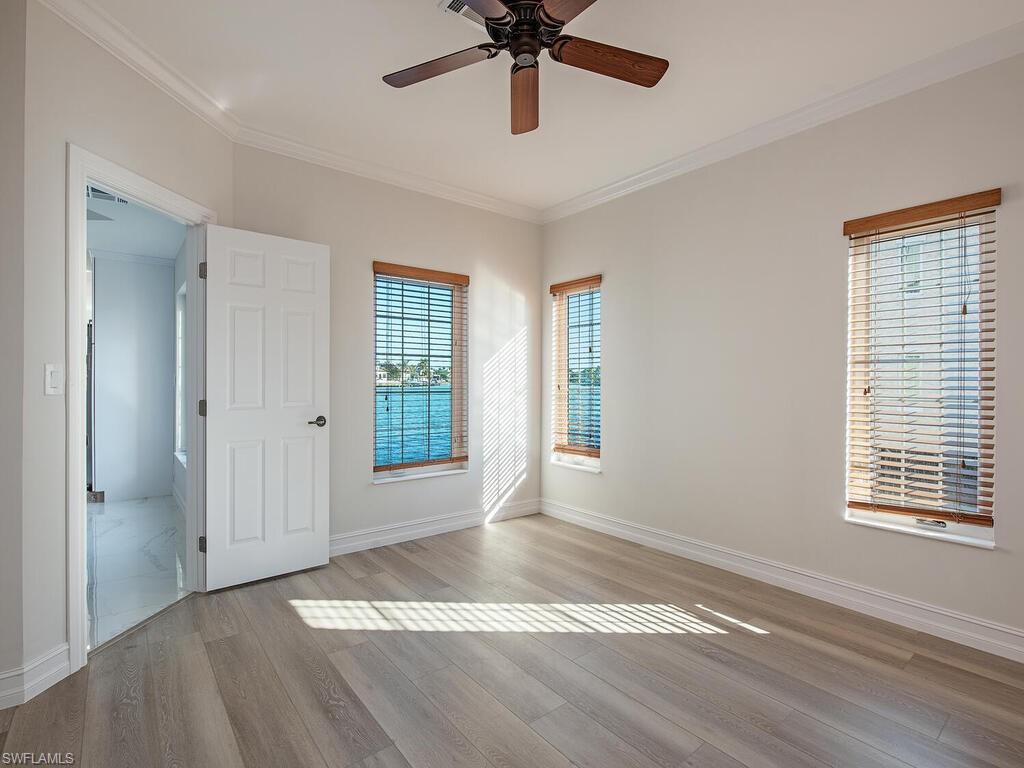 Unfurnished room with ceiling fan, crown molding, and light hardwood / wood-style flooring