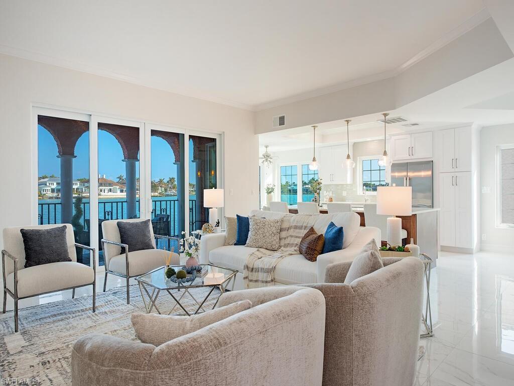 Living room featuring crown molding and a water view